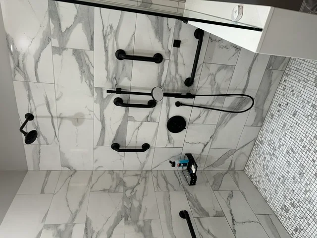 Overhead view of marble-look tile bathroom with black fixtures and hardware