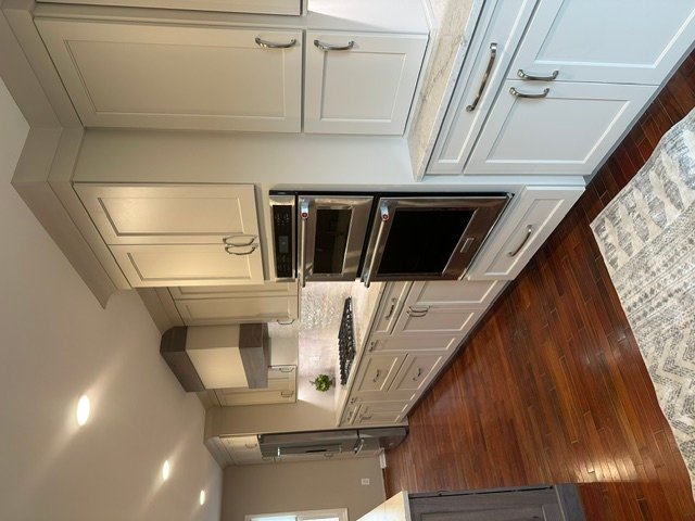 Cream-colored kitchen cabinets with glass doors and brushed nickel hardware