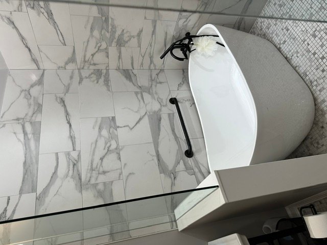 Bathroom with marble-look tile flooring and white vanity sink