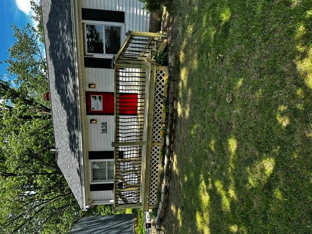 New residential deck with lattice skirting and wooden stairs leading to updated entry door