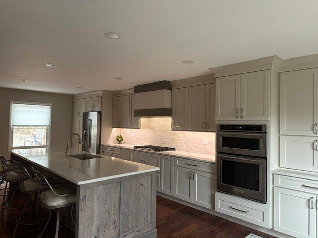 Modern kitchen with gray cabinetry, island, and stainless steel appliances